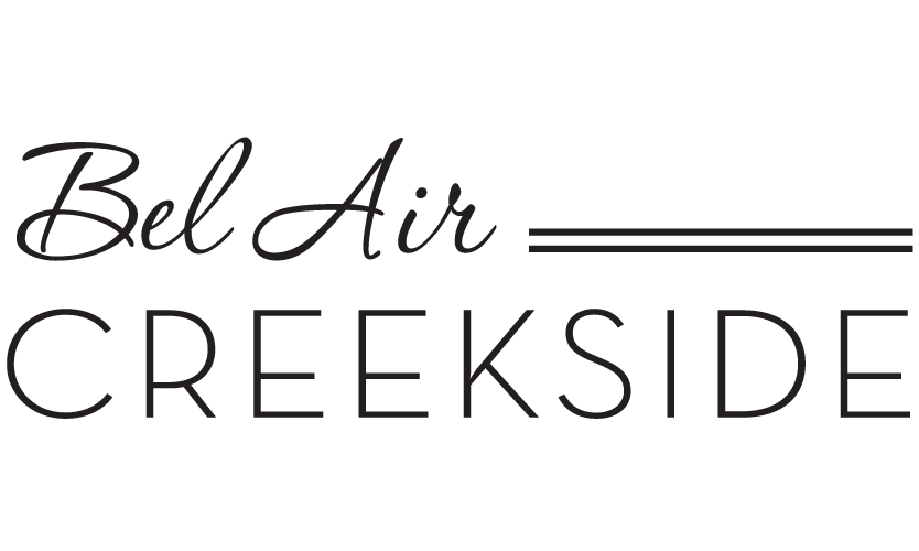 A green sign with the words Bel Air and Creekside on it.